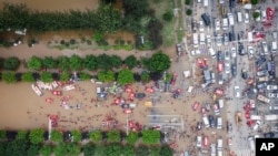 中國北部河北省涿州市洪水期間，救援人員部署救生筏疏散居民。 （美聯社）