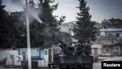 一名叙利亚自由军战士2012年12月23日在叙利亚政府军在伊德利卜附近发动空袭行动时候，使用高射炮向政府军战机开火