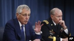 美國國防部長哈格爾（左）與美國參謀長聯席會議鄧普西12月19日在國防部舉行的記者會上