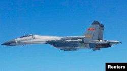 日本國防部5月25日公佈的圖片顯示﹐一架中國SU-27戰機於24日在東中國海上空飛行。