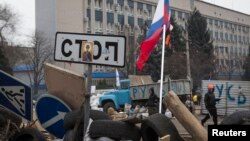 手舉俄羅斯國旗的親俄羅斯示威者4月10日在烏克蘭的盧甘斯克安全部門外。