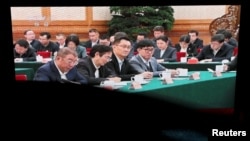 北京某購物中心的巨型電子螢幕播放的新聞畫面顯示，數位知名中國營企業家在北京舉行的座談會上聽取中國領導人習近平講話的場景。 （2025年2月17日）