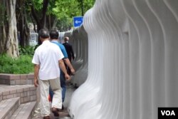 行人要在大型水馬陣的狹縫中走路。(美國之音湯惠芸)