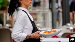 ພະນັກງານເສີບອາຫານຢູ່ຮ້ານອາຫານແຫ່ງນຶ່ງ.