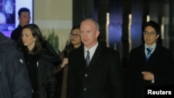 美國副貿易代表杰弗里·格里什(中）2019年1月7日離開北京一家酒店前往會場的情景（路透社）