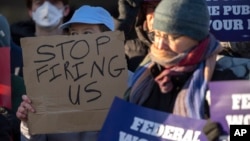 FILE - Demonstrators rally in support of federal workers outside of the U.S. Department of Health and Human Services on Feb. 14, 2025, in Washington. A federal judge on March 13, 2025, ordered six U.S. agencies to reinstate some fired workers.
