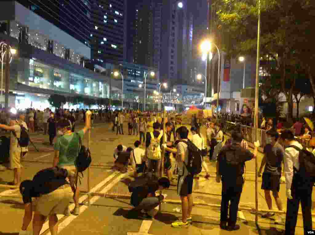 数以百计占中支持者在金钟道从中银大厦至警察总部长达150的路段上加固多处路障 (美国之音海彦 拍摄)