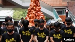 香港大學的學生在悼念六四死難者的“國殤之柱”前向死難者默哀。 （2021年6月4日）
