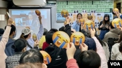 多個香港基層民間組織2月26日舉行財政預算案直播活動，參與的基層市民普遍對新一份財政預算案持負面觀感，大部份高舉流淚的表情符號。(美國之音照片)