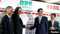 日本首相安倍晋三（中右）等人在选举之夜的活动中
