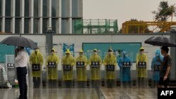 位于深圳的恒大集团总部外警察穿着雨衣在站岗。（2021年9月14日）