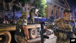 资料照：瓦格纳雇佣军士兵在俄罗斯罗斯托夫的街道上往一辆拖运车上装载坦克。(2023年6月24日)