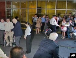 一名女子手持鮮花試圖擁抱陳光誠，被保安阻止。