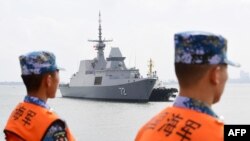 一艘新加坡海軍艦艇抵達中國南部廣東省湛江市的一個軍事港口時，中國水手在一旁觀看。（2018年10月21日）