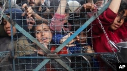 加沙地带贾巴里亚难民营的巴勒斯坦人正在等待领取免费食品。（2024年3月18日）