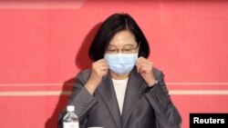 台灣總統蔡英文在台北出席會議期間整理口罩以防新冠感染。（2020年8月19日）