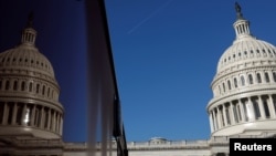 资料照：美国国会大厦和在一处玻璃幕墙上的大厦影子。