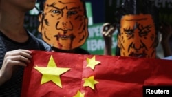 菲律宾学生头戴杜特尔特总统和中国国家主席习近平的漫画脸谱举行反华示威集会（路透社2018年11月20日）