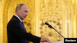 普京在莫斯科克里姆林宫举行的就职典礼上手按宪法第四次宣誓就任俄罗斯总统。（2018年5月7日）