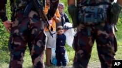 匈牙利士兵拦住一家希望从塞尔维亚进入匈牙利的移民或难民。 （2015年9月15日）