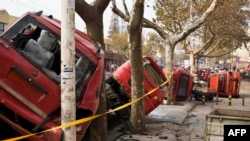 11月22日，青岛输油管爆炸后，受损的车辆倒在一条街上