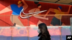 资料照片：2021年3月25日，一名妇女走过北京一家耐克产品专卖店。（美联社照片）