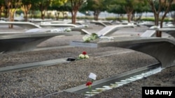 资料照：2024年9月11日，弗吉尼亚州阿灵顿国家9/11五角大楼纪念园举行第23届9/11纪念花圈敬献仪式，纪念长椅上摆放着鲜花。