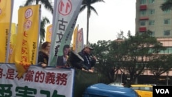 吾尔开希在竞选卡车上。他周四，即台湾选举日前夕，冒雨在台北街头做竞选宣传。（美国之音萧洵摄影）