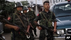 2013年10月28日緬甸克欽獨立軍(KIA)士兵站在中緬邊境城鎮拉札的道路上維持安全。