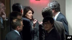 美国驻联合国大使黑利(中)2018年2月24日就要求叙利亚停火30天的决议投票前，与其他安理会成员国代表交谈。