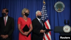 美国副总统迈克·彭斯（右）与美国卫生与公共服务部长亚历克斯·阿扎尔（左）和教育部长贝茜·德沃斯（中）举行简报会。（2020年7月8日）