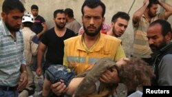 醫護人員抱著一個死於阿勒頗空襲的孩子的屍體（2016年10月4日）