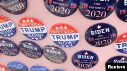 FILE - Biden for President campaign buttons are for sale beside "Impeach Trump Now!" buttons as U.S. Democratic presidential candidate and former Vice President Joe Biden meets union workers at the Teamsters Local 249 hall in Pittsburgh, April 29, 2019.