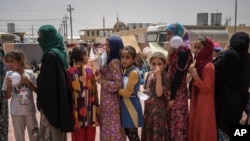 妇女和儿童在伊拉克的一个难民营排队领取食物（资料照）