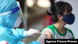 2021年10月27日，越南胡志明市的一所小学，医务人员为青少年接种辉瑞新冠病毒疫苗。