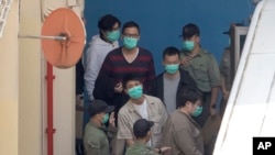 前香港立法會議員林卓廷（穿紅衣者）在2021年3月2日從監獄前往法庭。（美聯社資料照片）