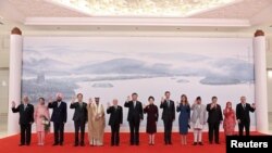 中国国家主席习近平和夫人彭丽媛与出席杭州亚运会的外国领导人合影。