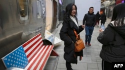 2019年1月6日，中國購物者在北京一個熱門購物中心，長椅上畫著美國國旗圖案。