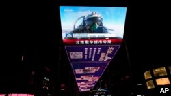 资料照片：北京一个户外屏幕上显示的一名中国战斗机飞行员在演习中竖起大拇指。(2023年4月10日)