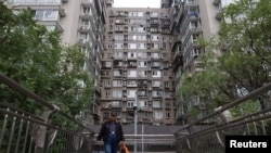 一名男子走過北京一棟住宅大樓旁的人行天橋。 （2024年10月17日）