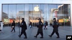 一队保安从北京一家苹果商店前走过。（2019年3月6日）