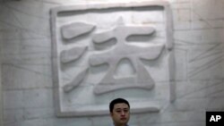 一名男子走过中国一家法院刻有“法”字的墙壁。（资料照片）