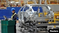 一名中國工人在重慶的福特汽車製造生產線上 （2012年4月20日）