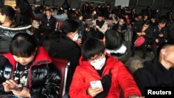 在北京西客站等候前往武漢的旅客戴著口罩在候車室裡候車。 （2020年1月20日）