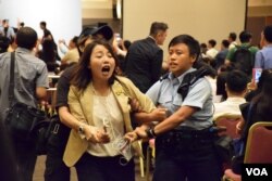 參選九龍西地區直選的劉小麗在簡介會場內抗議被保安及警員帶走。（美國之音湯惠芸攝）