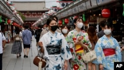 身穿和服戴著口罩的日本少女走在東京購物街上。 （2021年8月13日）