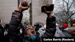 人们在明尼苏达州亨内平郡政府中心外听到前警察肖文被判谋杀弗洛伊德的罪名成立后做出反应。(2021年4月20日)