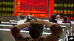 一位投資者在北京一家證券公司觀看股市走向顯示屏。 （2015年8月21日）