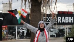 ແມ່​ຍິງ​ຄົນ​ນຶ່ງ​ຍົກ​ທຸງ​ຊາດ ເລ​ບາ​ນອນ ແລະ ປາ​ແລັ​ສ​ໄຕ​ນ໌ ໃນ​ຂະ​ນະ​ທີ່​ລາວ​ທັກ​ທາຍ​ປະ​ຊາ​ຊົນ​ໃນ​ເມືອງ ຊີ​ດອນ ທາງ​ພາກ​ໃຕ້​ຂອງ ເລ​ບາ​ນອນ, 27 ພະ​ຈິກ 2024. (Photo by anwar amro / AFP)