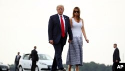 特朗普总统和第一夫人梅拉妮亚在法国比亚里茨七国集团峰会结束后走向“空军一号”专机，启程返美。(2019年8月27日)